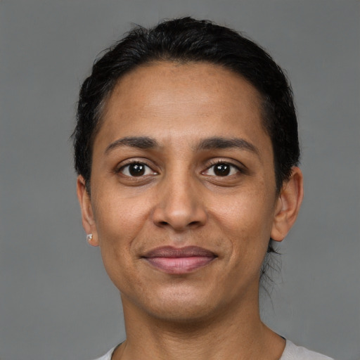 Joyful latino adult female with short  brown hair and brown eyes