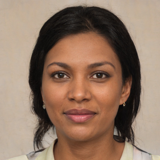 Joyful black young-adult female with medium  brown hair and brown eyes