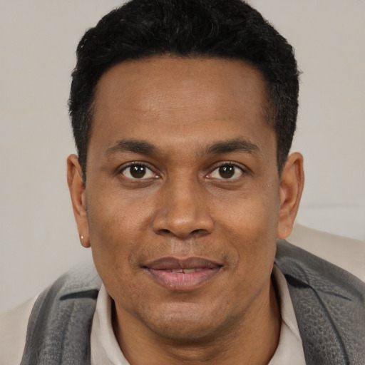 Joyful black young-adult male with short  black hair and brown eyes