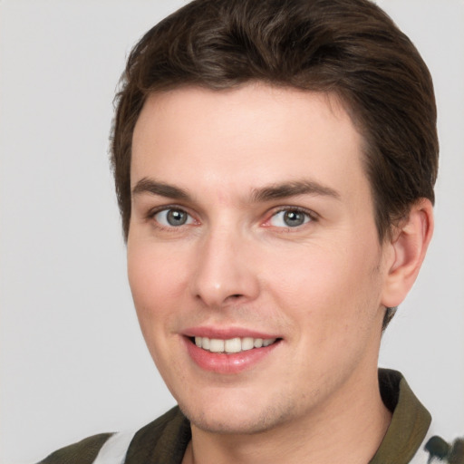 Joyful white young-adult male with short  brown hair and grey eyes