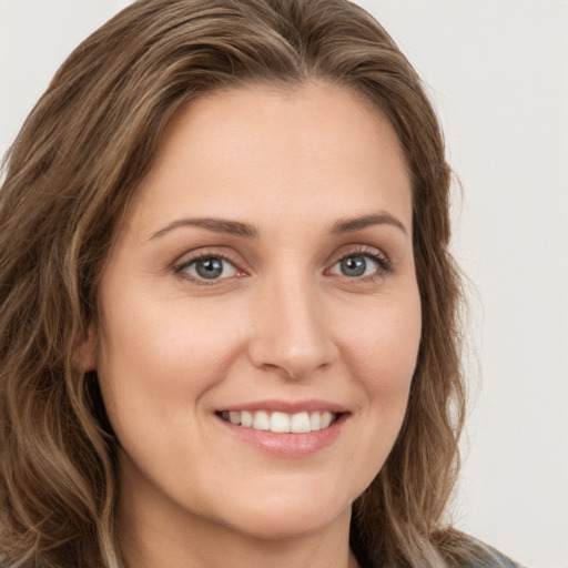 Joyful white young-adult female with long  brown hair and green eyes