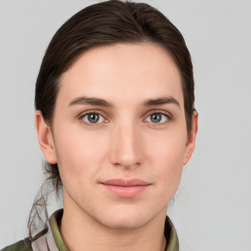 Joyful white young-adult female with short  brown hair and grey eyes