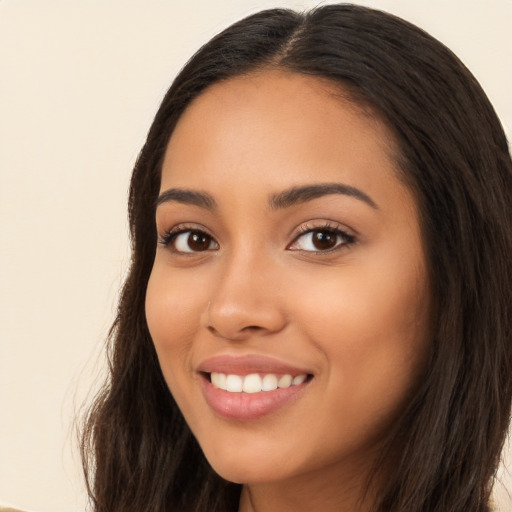 Joyful latino young-adult female with long  brown hair and brown eyes