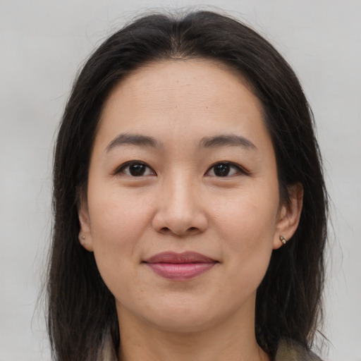 Joyful asian young-adult female with long  brown hair and brown eyes