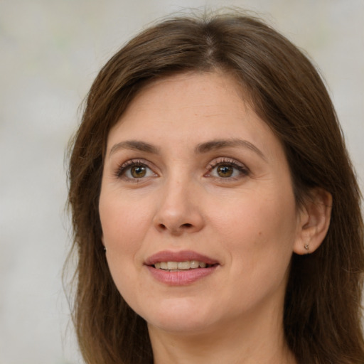 Joyful white young-adult female with long  brown hair and green eyes