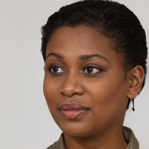 Joyful black young-adult female with short  black hair and brown eyes