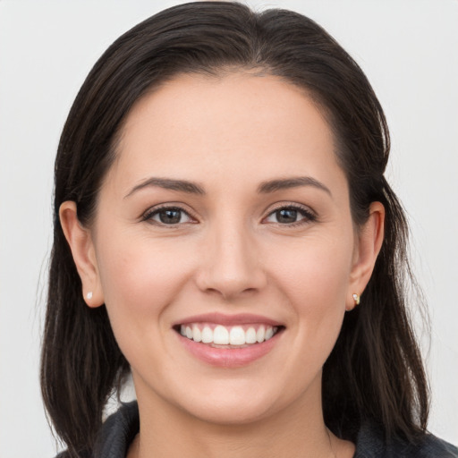 Joyful white young-adult female with long  brown hair and brown eyes