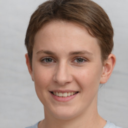 Joyful white young-adult female with short  brown hair and grey eyes