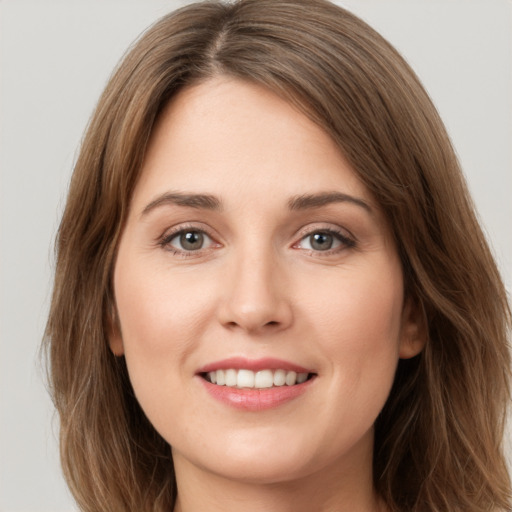 Joyful white young-adult female with long  brown hair and green eyes