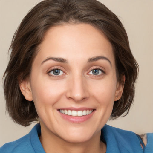 Joyful white young-adult female with medium  brown hair and grey eyes