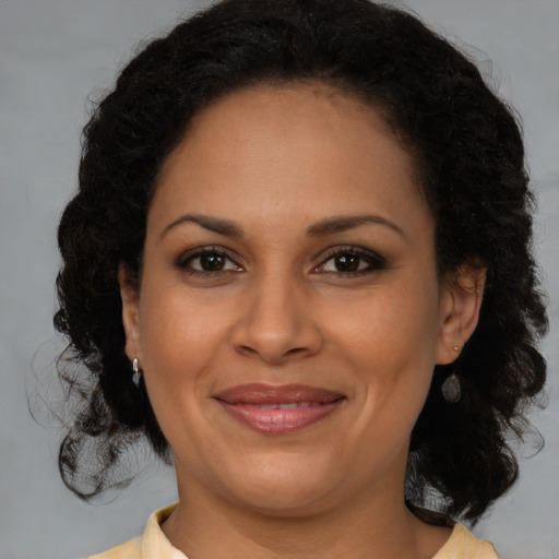 Joyful black adult female with medium  brown hair and brown eyes