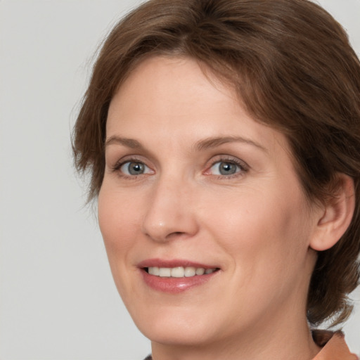 Joyful white adult female with medium  brown hair and grey eyes