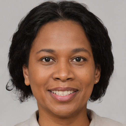 Joyful black adult female with medium  brown hair and brown eyes