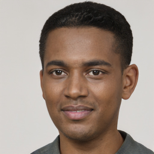Joyful black young-adult male with short  black hair and brown eyes
