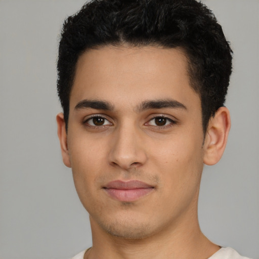 Joyful latino young-adult male with short  black hair and brown eyes