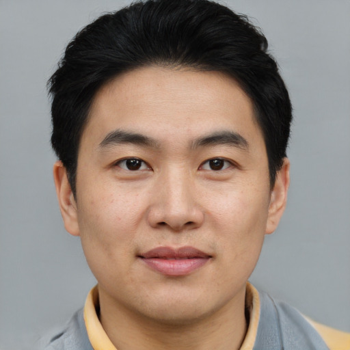 Joyful asian young-adult male with short  brown hair and brown eyes