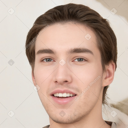 Joyful white young-adult male with short  brown hair and grey eyes