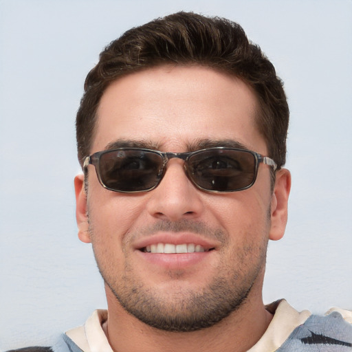 Joyful white young-adult male with short  brown hair and blue eyes