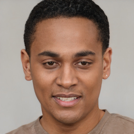 Joyful black young-adult male with short  black hair and brown eyes