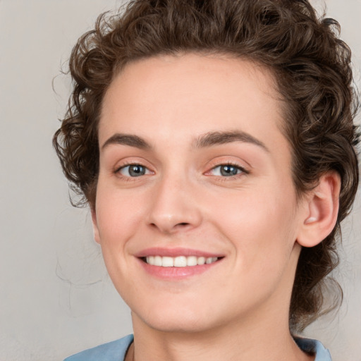 Joyful white young-adult female with medium  brown hair and blue eyes