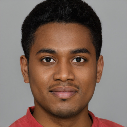 Joyful black young-adult male with short  black hair and brown eyes