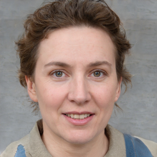 Joyful white adult female with medium  brown hair and blue eyes