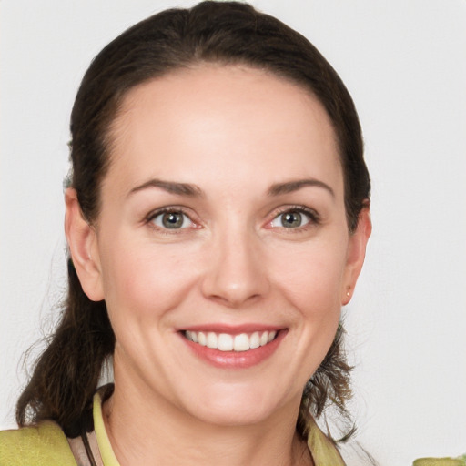 Joyful white young-adult female with medium  brown hair and green eyes