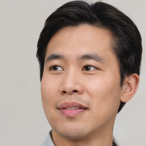 Joyful asian adult male with short  black hair and brown eyes