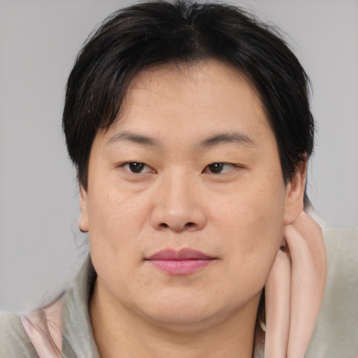 Joyful asian young-adult male with medium  brown hair and brown eyes