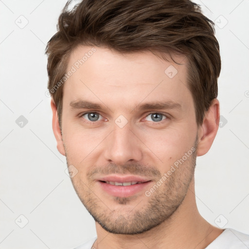 Joyful white young-adult male with short  brown hair and grey eyes