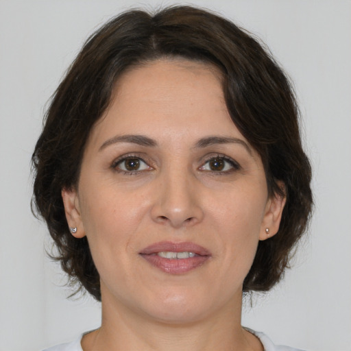 Joyful white adult female with medium  brown hair and brown eyes