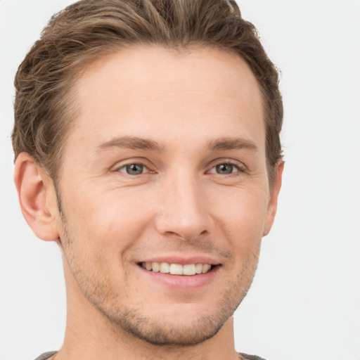 Joyful white young-adult male with short  brown hair and grey eyes