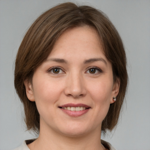 Joyful white young-adult female with medium  brown hair and grey eyes