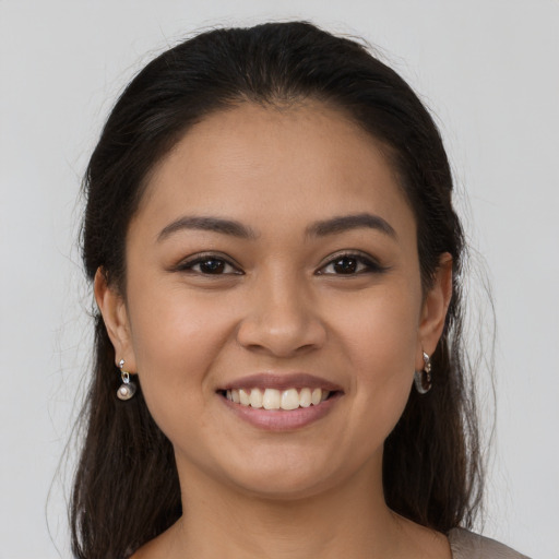 Joyful latino young-adult female with long  brown hair and brown eyes