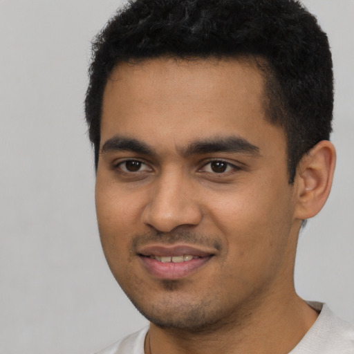 Joyful latino young-adult male with short  black hair and brown eyes