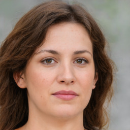 Joyful white young-adult female with medium  brown hair and green eyes