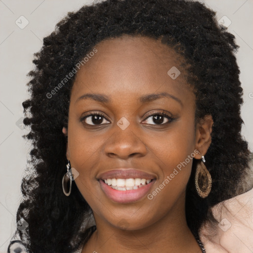 Joyful black young-adult female with long  brown hair and brown eyes