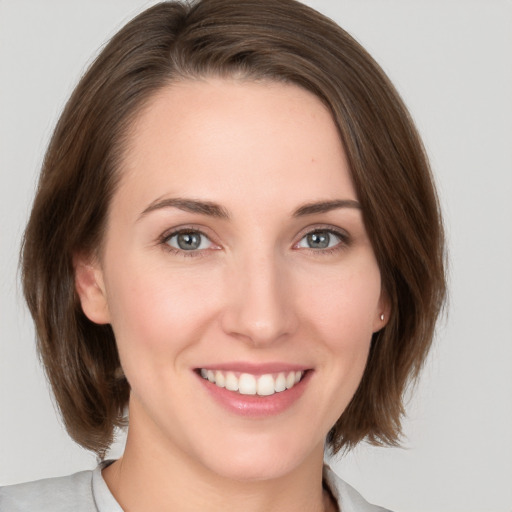 Joyful white young-adult female with medium  brown hair and green eyes