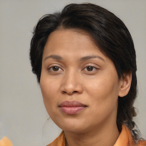 Joyful asian adult female with medium  brown hair and brown eyes