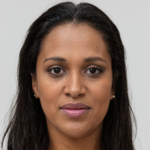 Joyful black adult female with long  brown hair and brown eyes