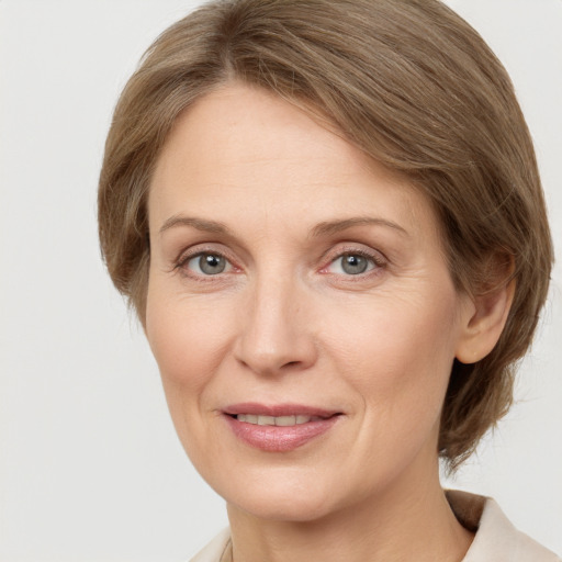 Joyful white adult female with medium  brown hair and grey eyes