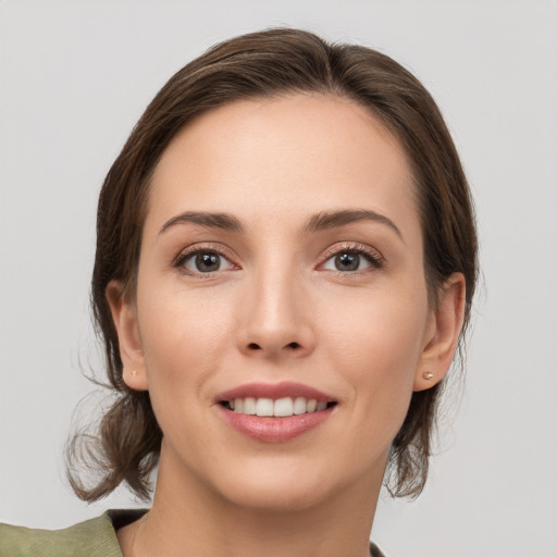 Joyful white young-adult female with medium  brown hair and grey eyes