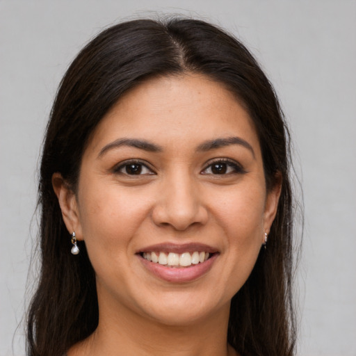 Joyful latino young-adult female with long  brown hair and brown eyes