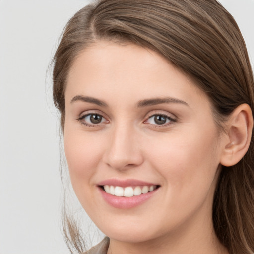 Joyful white young-adult female with long  brown hair and grey eyes