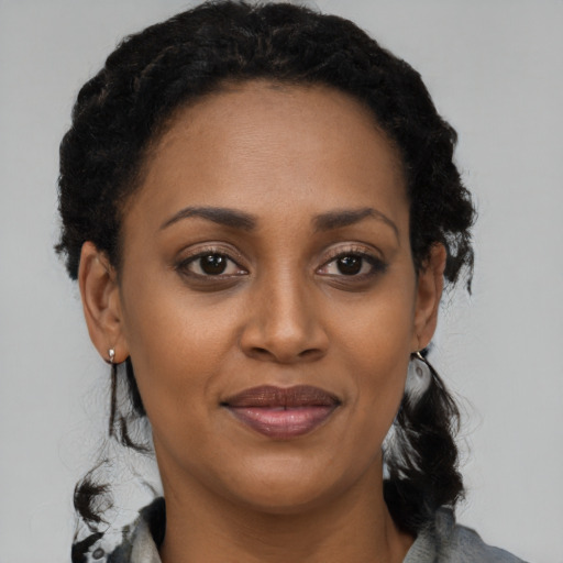 Joyful black adult female with short  brown hair and brown eyes
