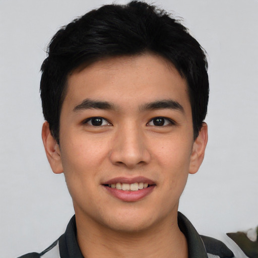 Joyful asian young-adult male with short  black hair and brown eyes