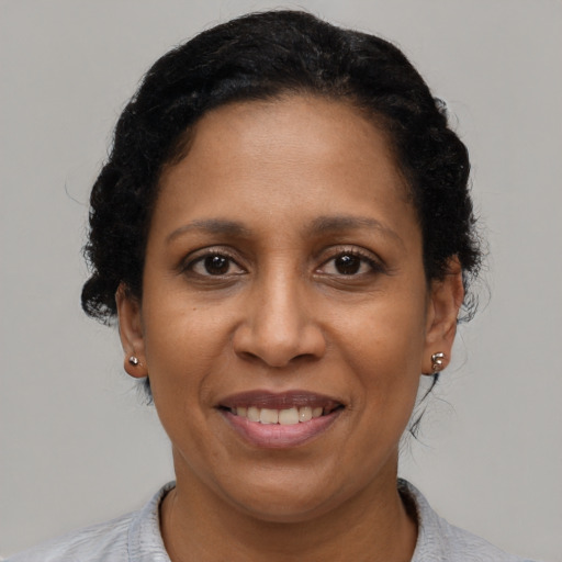 Joyful black adult female with short  black hair and brown eyes
