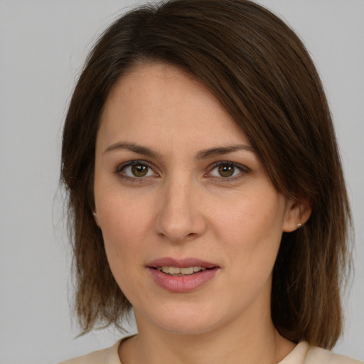 Joyful white young-adult female with medium  brown hair and green eyes