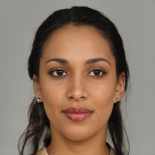 Joyful black young-adult female with long  brown hair and brown eyes