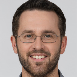 Joyful white adult male with short  brown hair and brown eyes